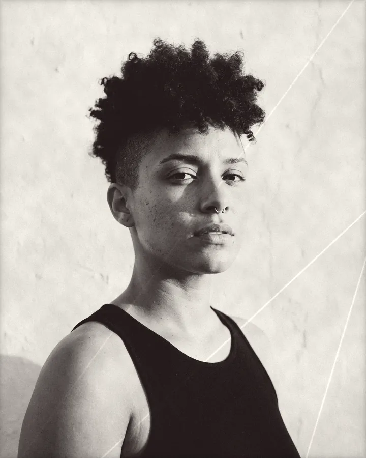 Portrait of a cool woman with shaved sides, a curly top and a septum ring, printed for the wall