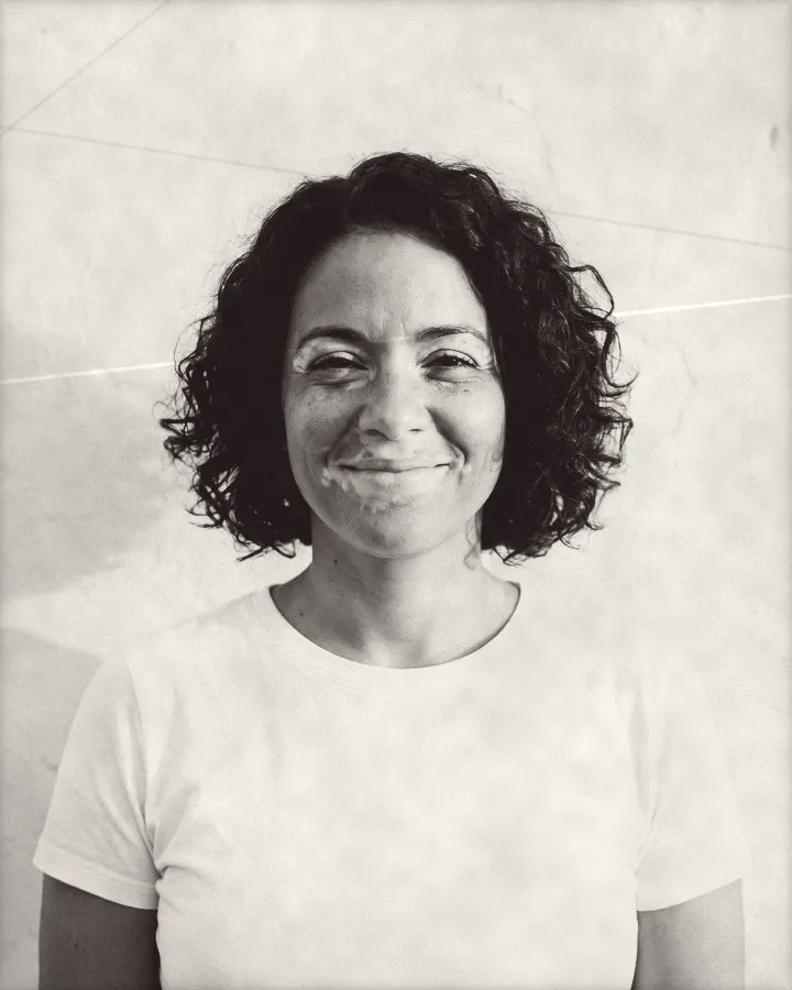 Portrait of a smiling woman with a curly chin-length bob, printed for the wall