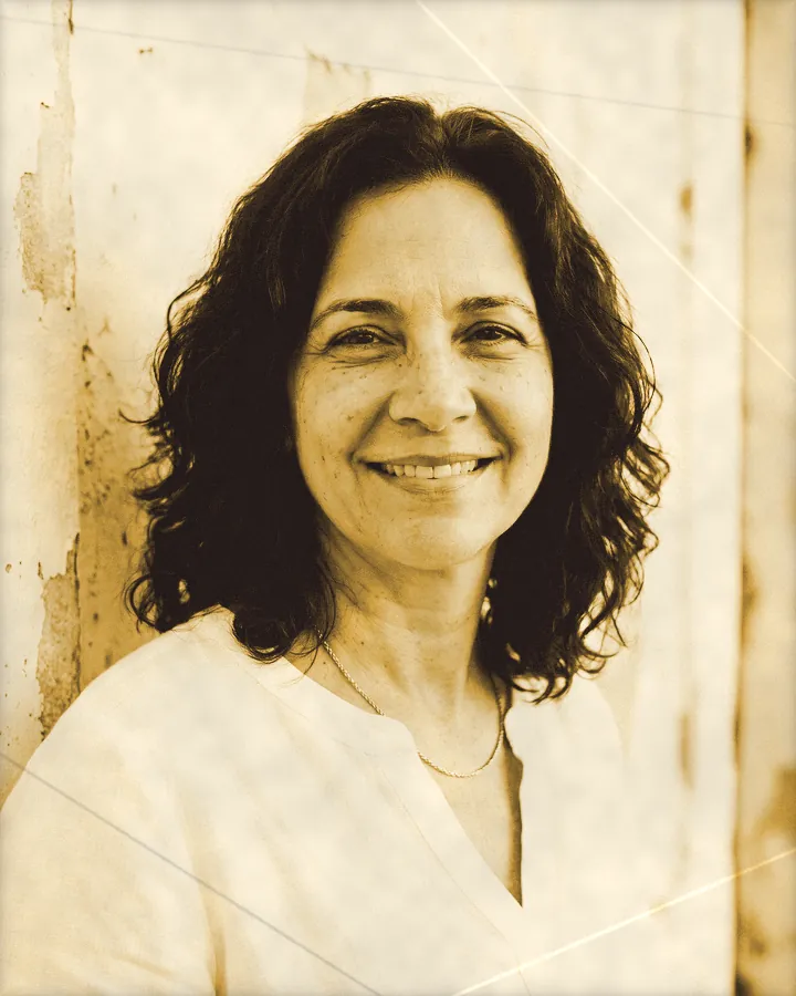Portrait of a radiant woman with wavy shoulder-length hair and a gold chain, printed for the wall