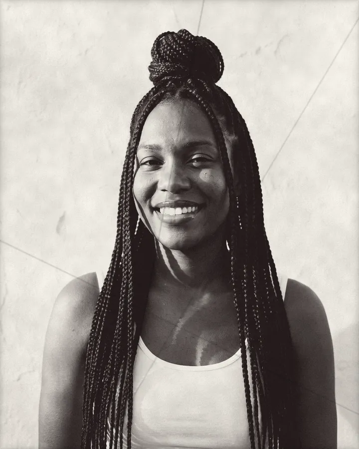 Portrait of a joyful woman with long braids wound into a high bun, printed for the wall