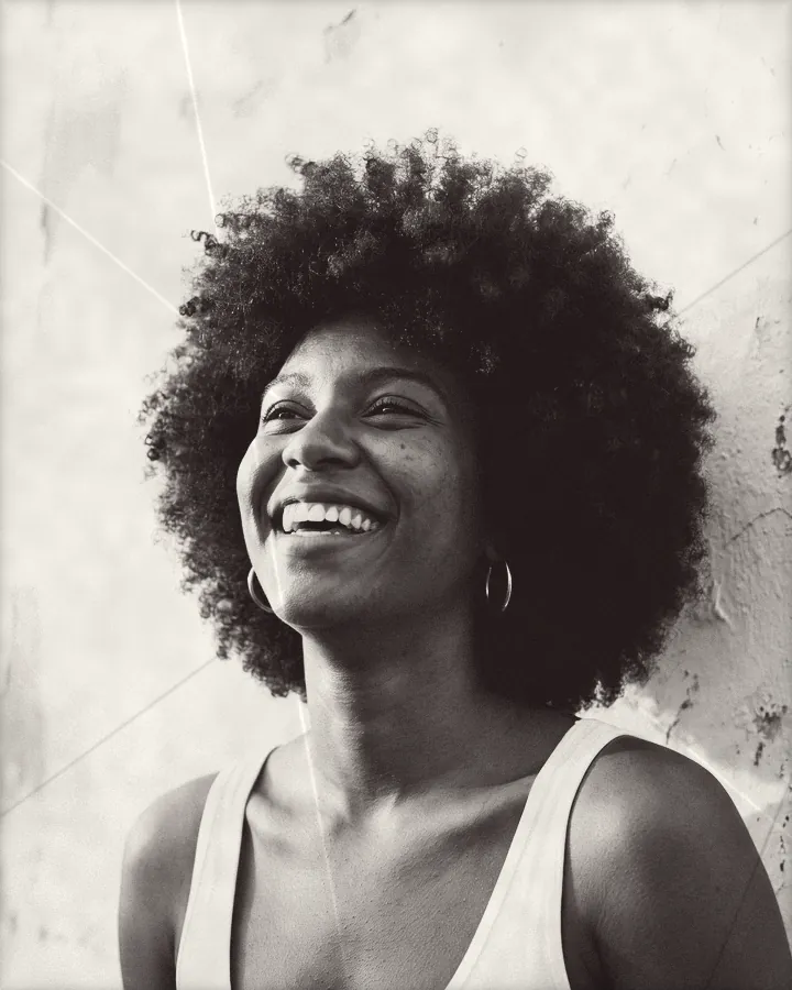 Portrait of a laughing young woman with a big round afro, printed for the wall