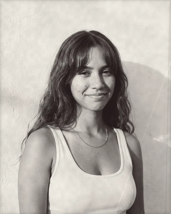 Portrait of a young woman with long wavy hair and curtain bangs, printed for the wall