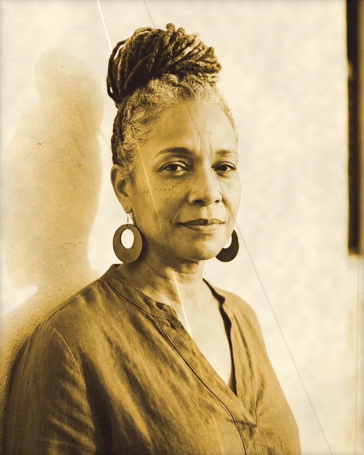 Portrait of a serene woman with salt-and-pepper locs in a high bun, printed for the wall